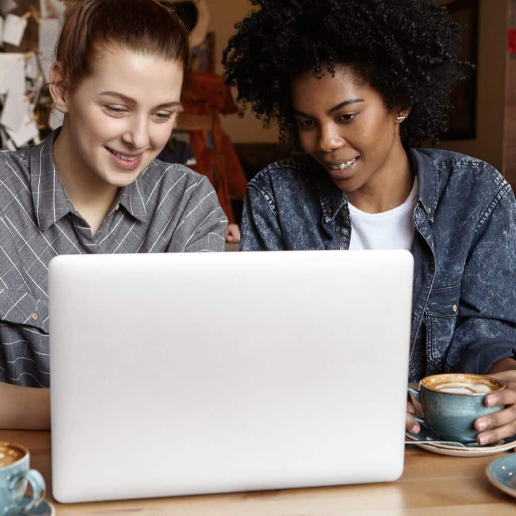 two-female-students-working-common-university-project-using-laptop-computer-together-cafe